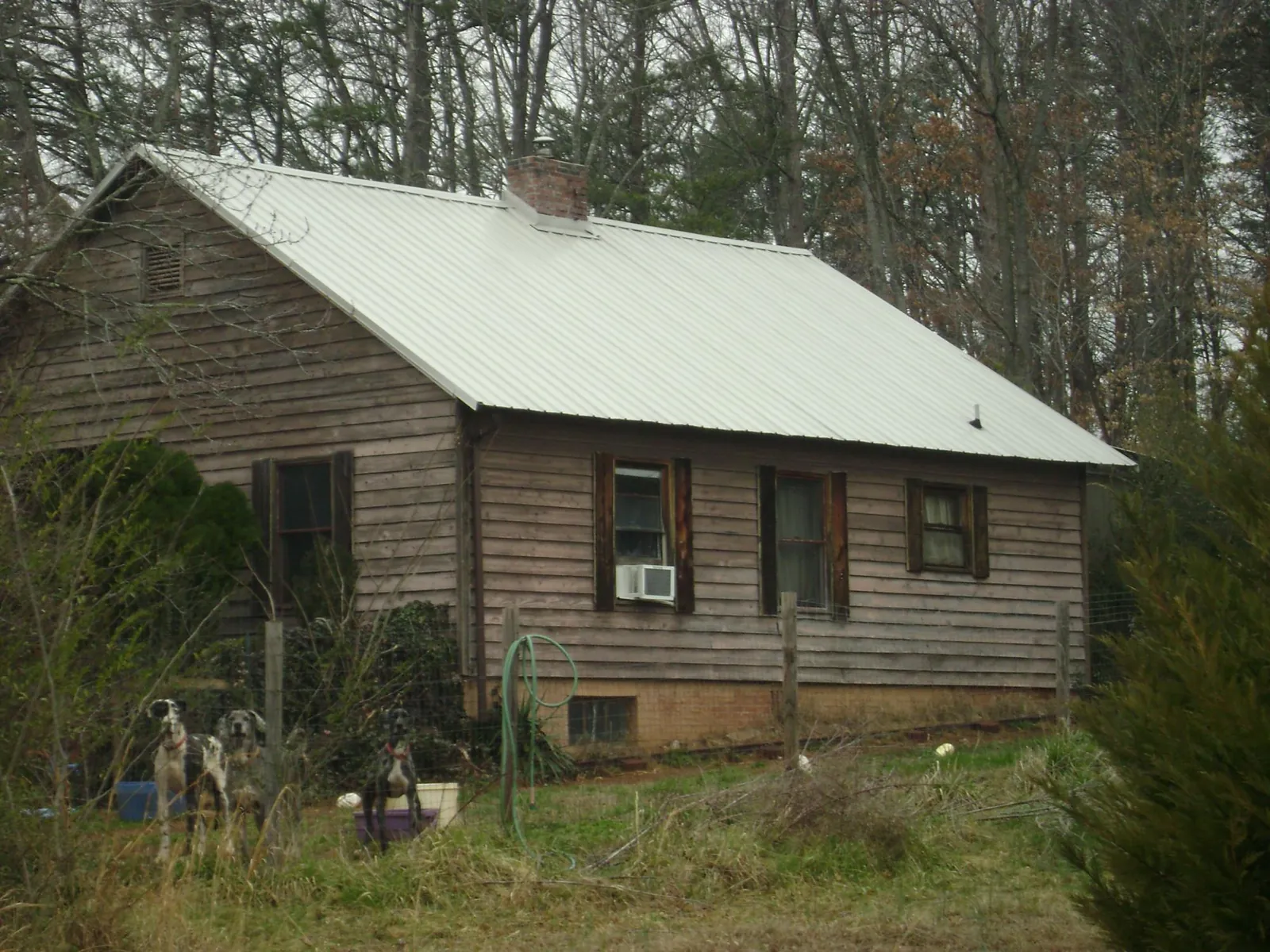 White metal roof on an old wood sided farmhouse, from a Metal Roof Installation job in Peoria
